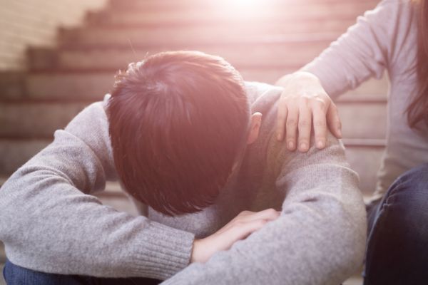 Man being consoled by friend